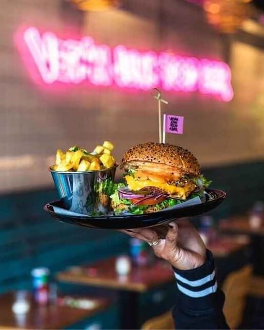 Интерьер бургерной Qazmaq: уютные столики, панорамные окна и тёплый свет